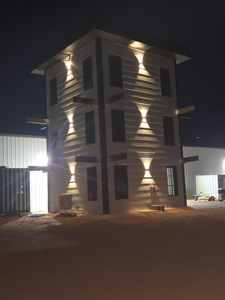 night photo of tall building with custom exterior lighting